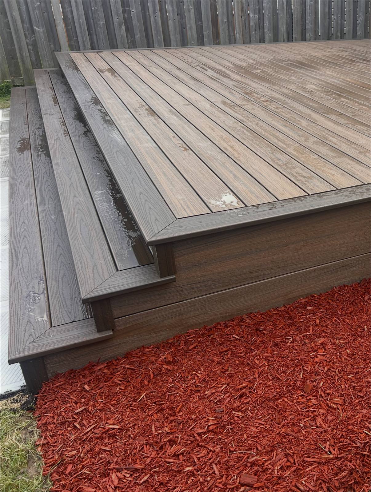 Low-maintenance deck beside a mulched garden bed, built by Gonzo Construction in the Kingston area