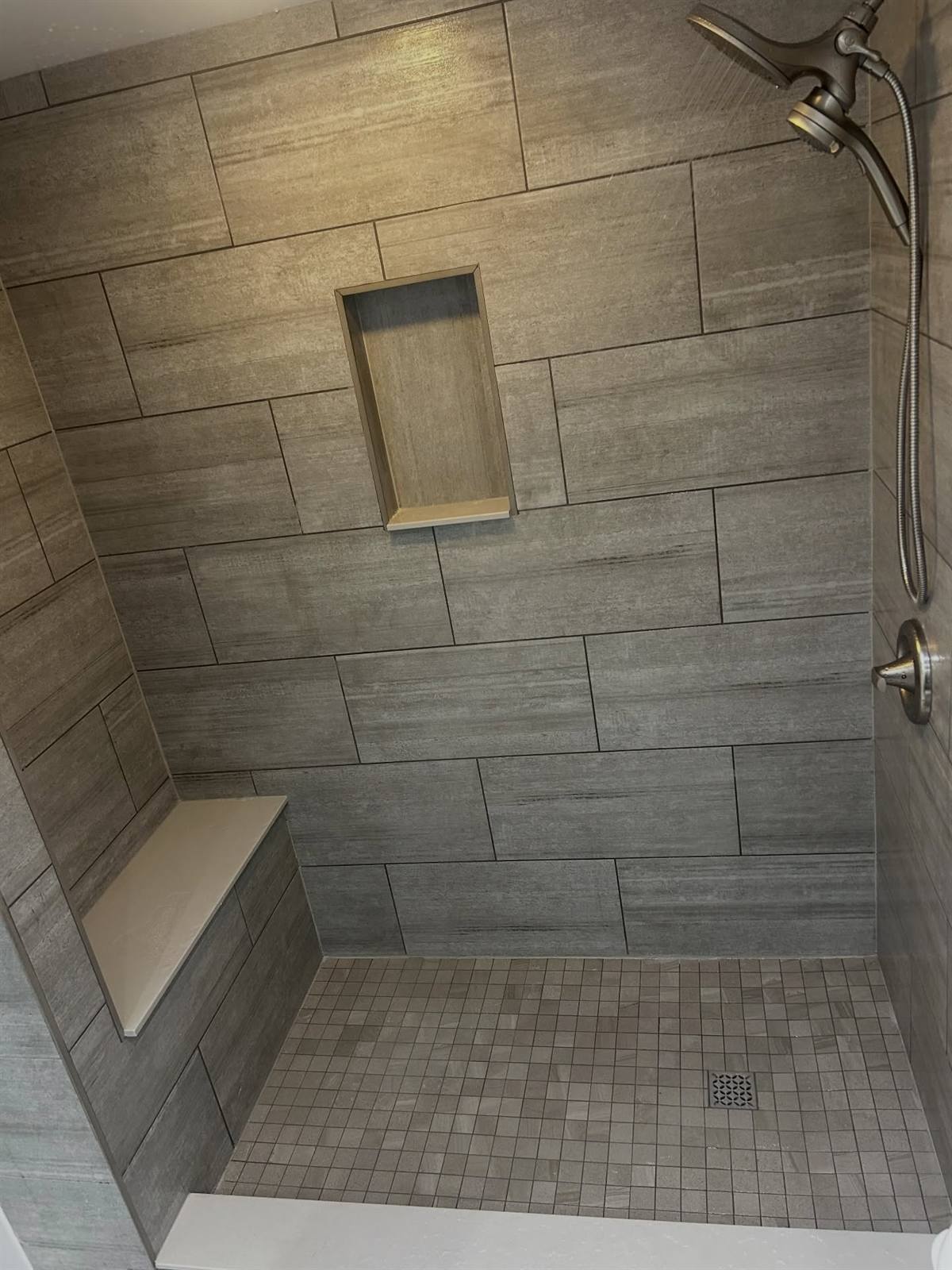 Custom tiled shower with bench and niche in a Kingston bathroom renovation