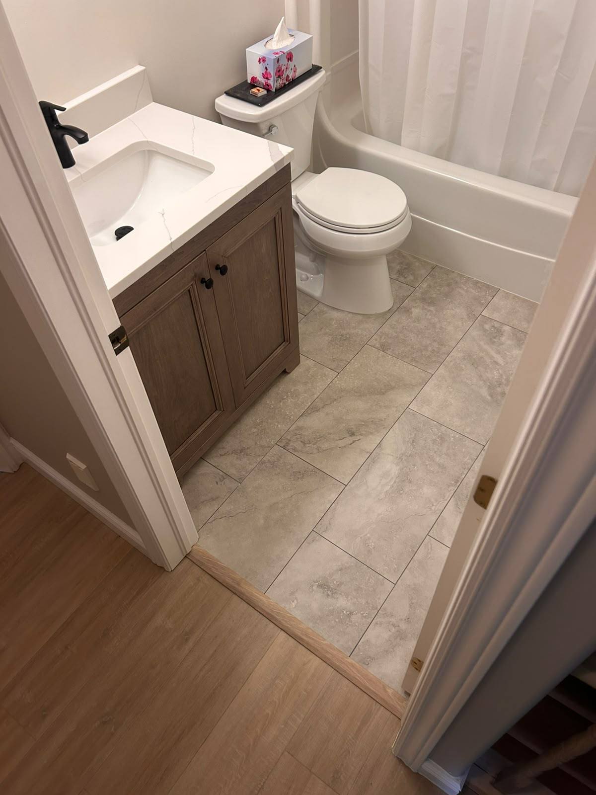 Bathroom renovation with new wood vanity, quartz top and tiled floor in Kingston, Ontario
