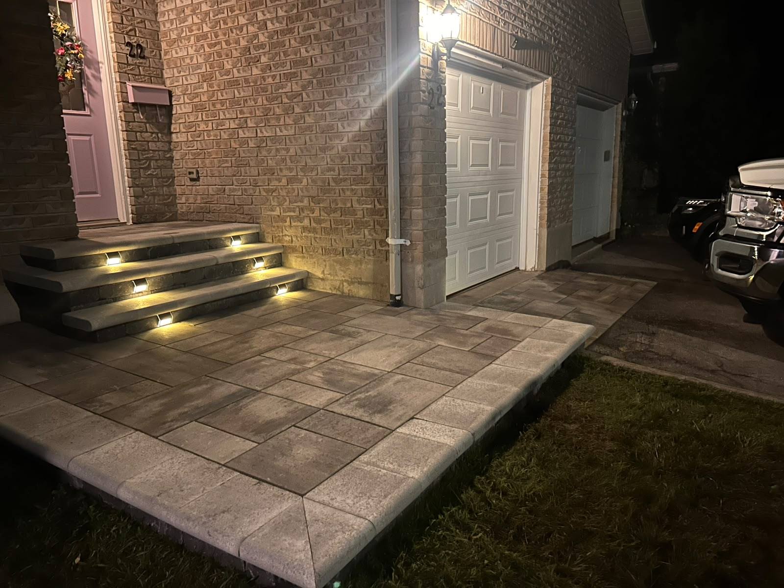 Interlock front entrance steps lit with recessed LED step lights at night in Kingston, Ontario