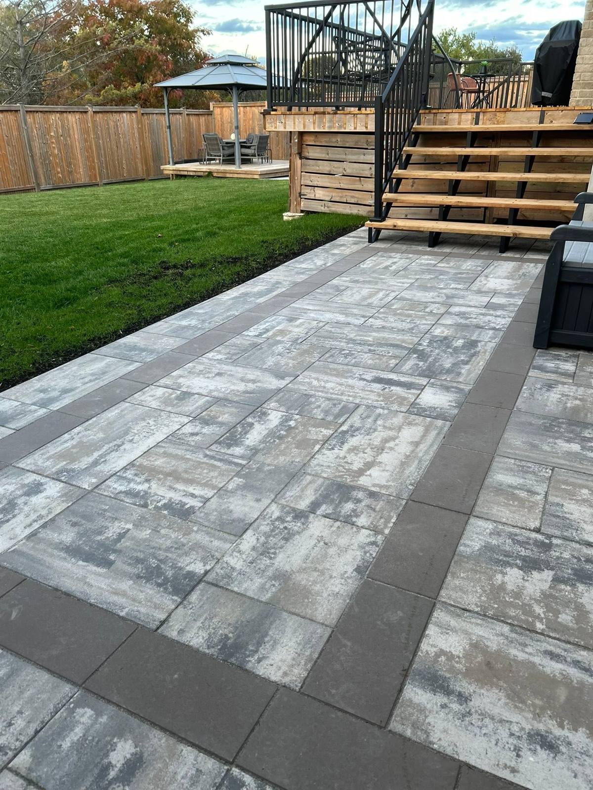 Interlock walkway with crisp border laid across a lawn in the Kingston area